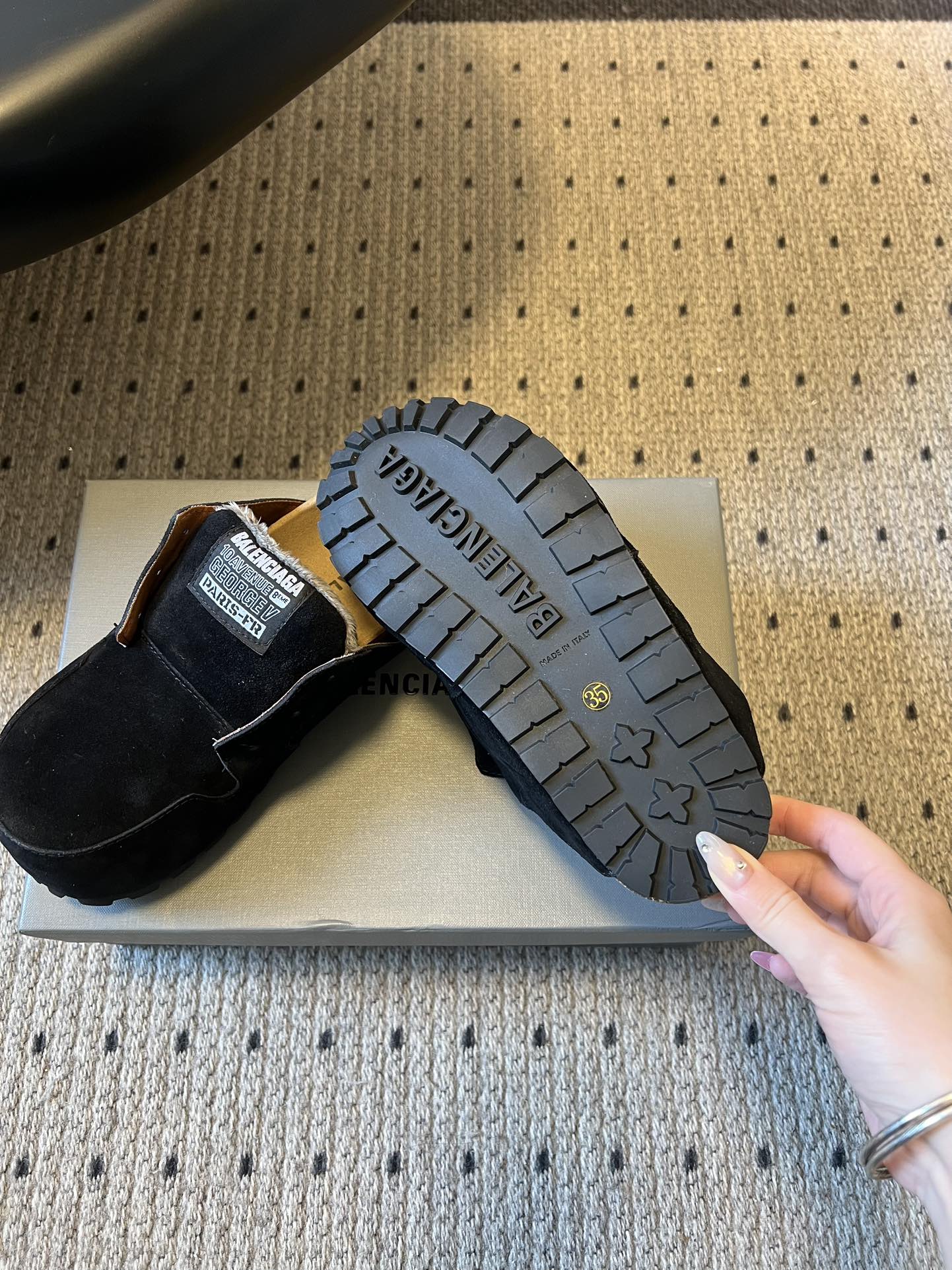Black suede slide sandals showing textured rubber outsole tread