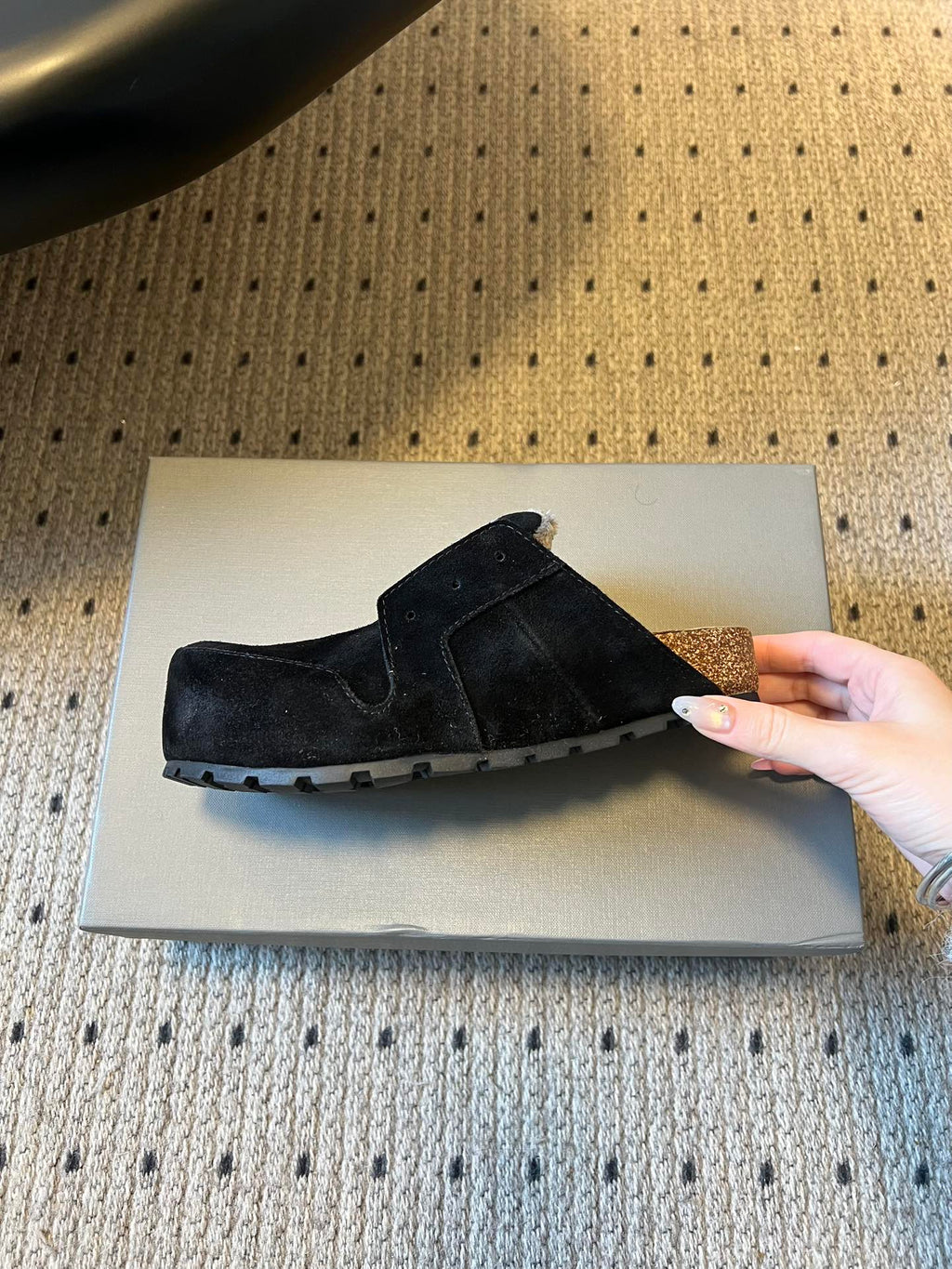 Black suede slip-on sandals with textured rubber sole and logo patch