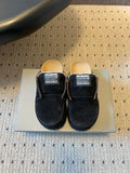 Black suede slide sandals with Balenciaga logo patches, closed-toe design