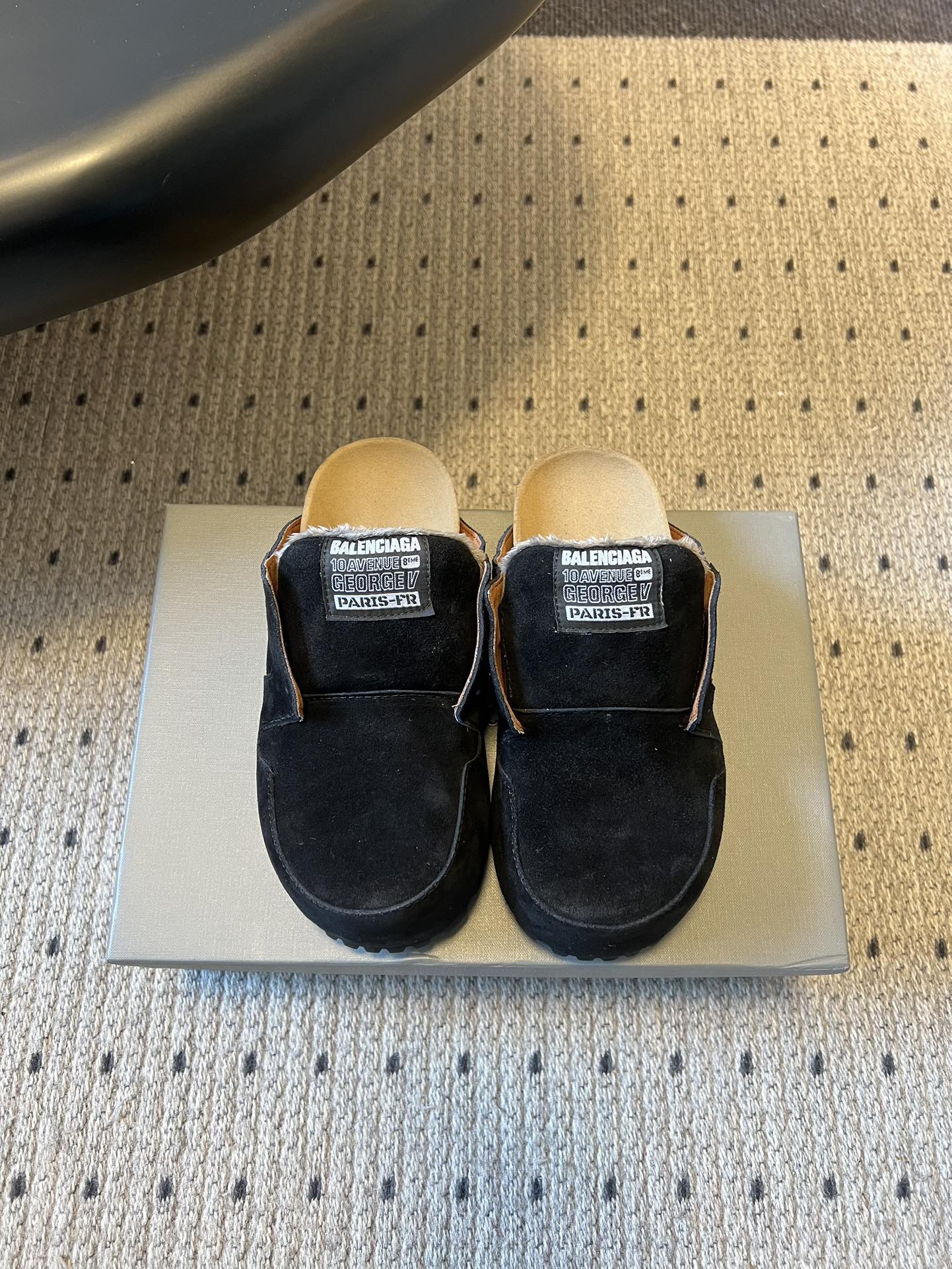 Black suede slide sandals with Balenciaga logo patches, closed-toe design