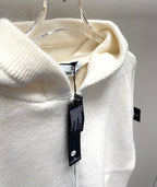 White zip-up hoodie hood close-up with hanging Stone Island product tag