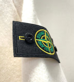 White hoodie sleeve dark patch with circular yellow Stone Island logo emblem