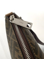 Close-up of monogram zip pocket with metal pull on textured dark canvas