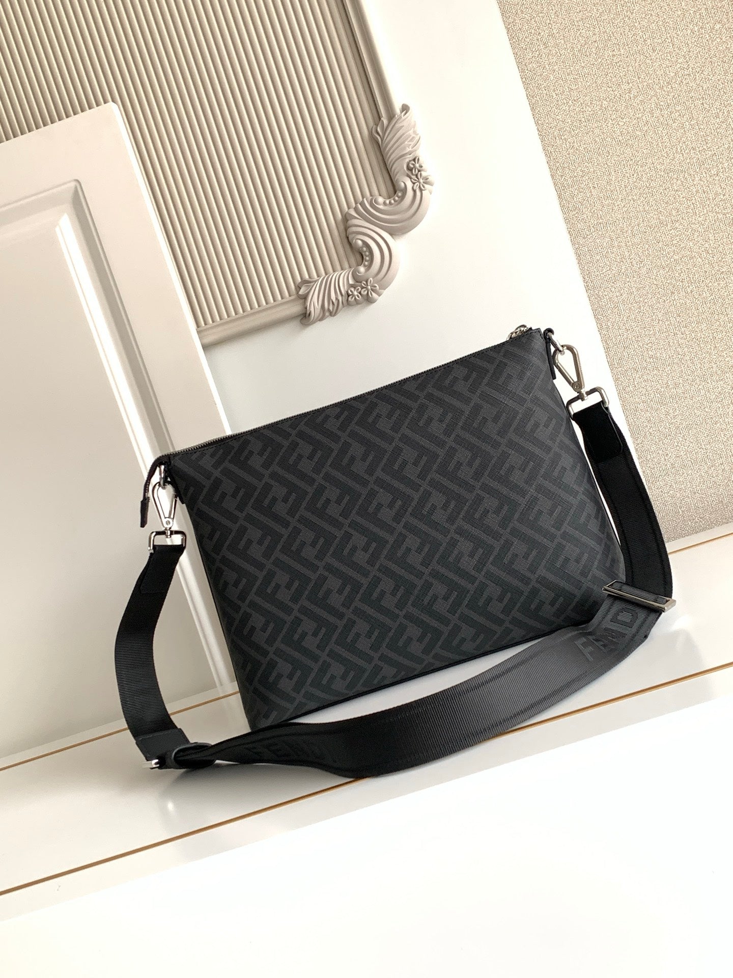 Fendi baguette-style bag in dark logo canvas with crossbody strap and zip top