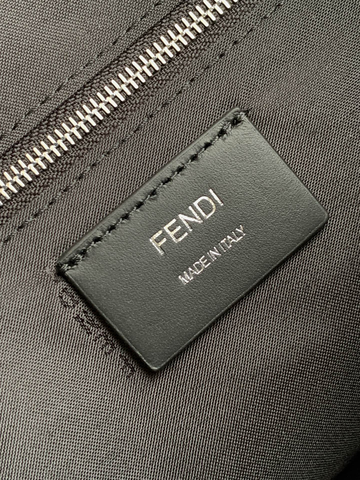 Fendi leather brand tag reading FENDI MADE IN ITALY on dark bag
