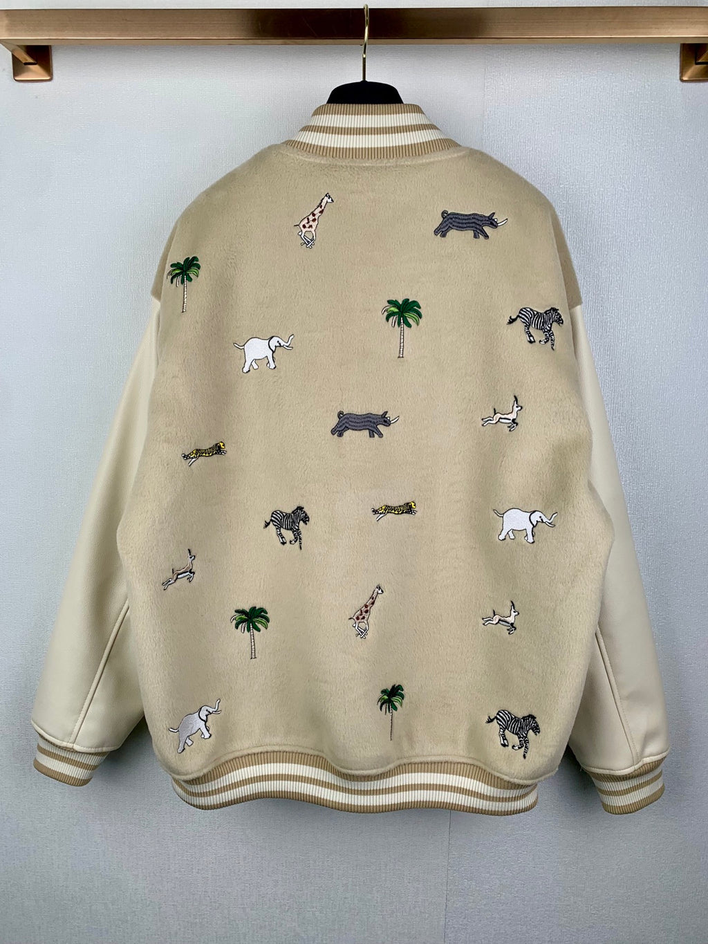 Beige Louis Vuitton varsity-style jacket with animal and palm pattern, ribbed hem and cuffs