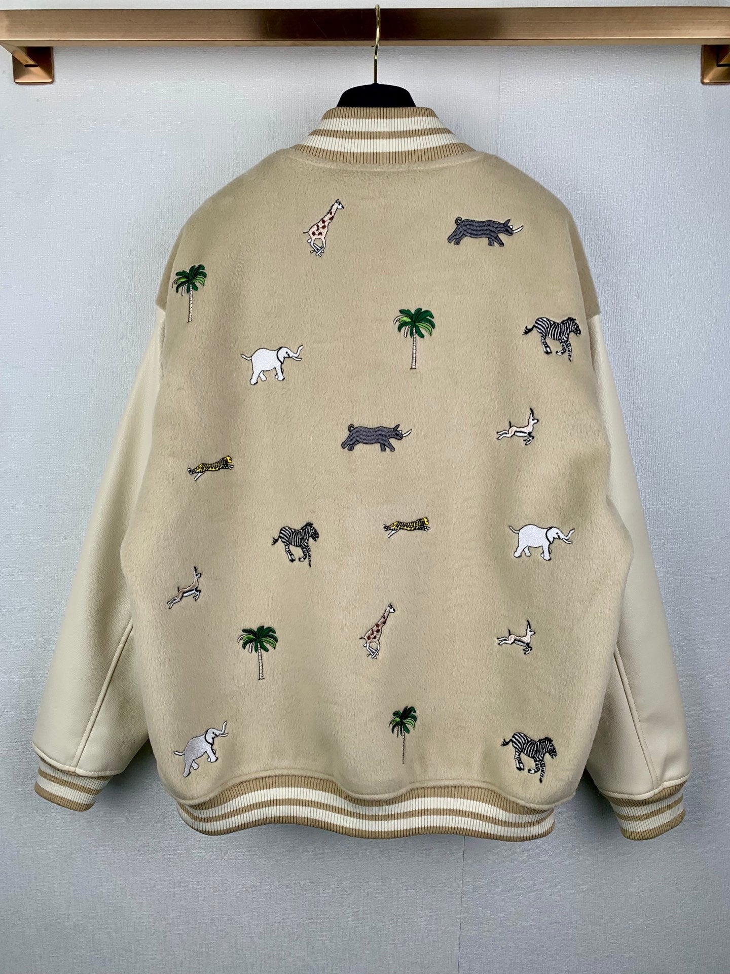Beige Louis Vuitton varsity-style jacket with animal and palm pattern, ribbed hem and cuffs