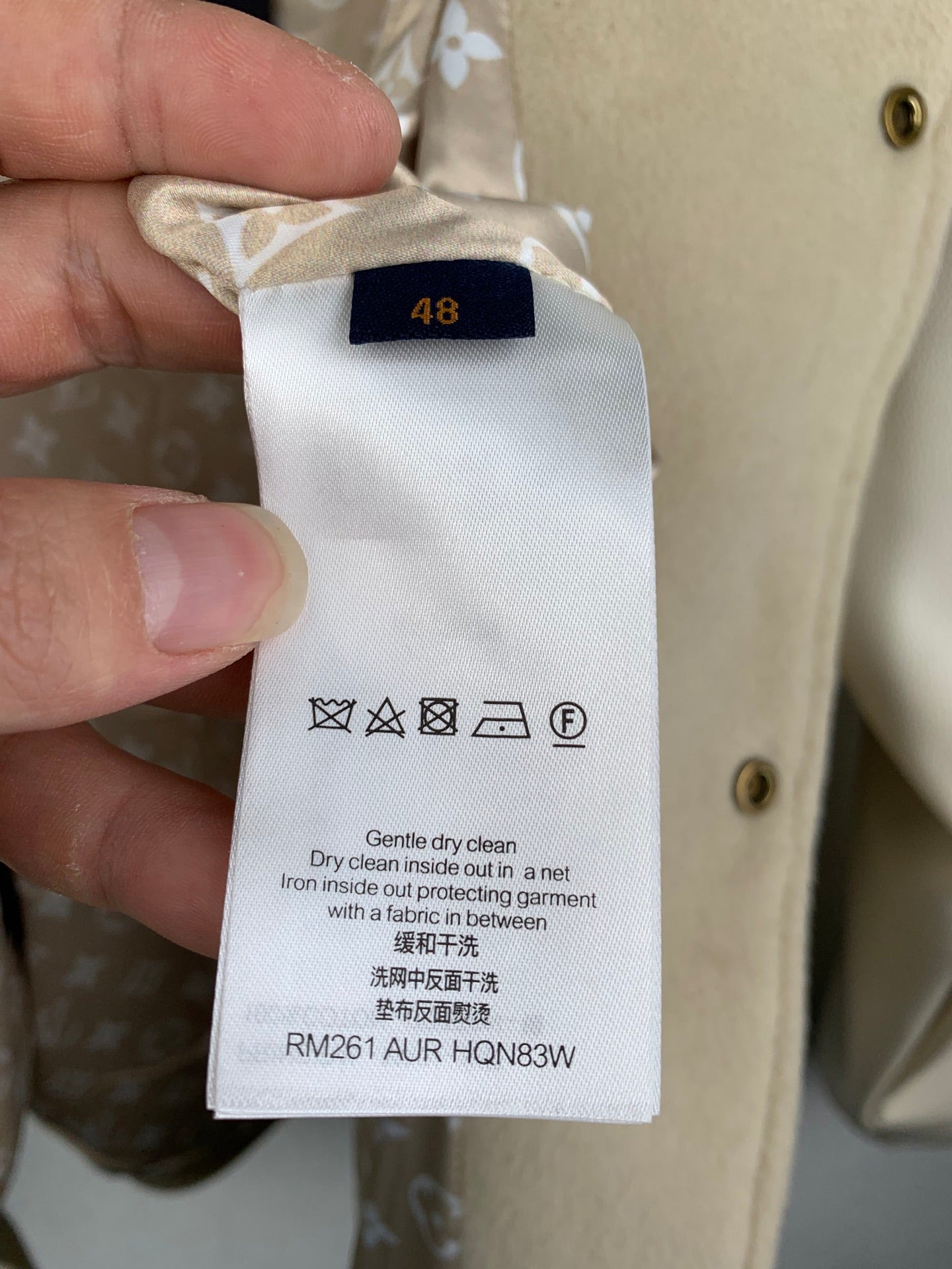 Cream clothing care label with size 48 and cleaning instructions