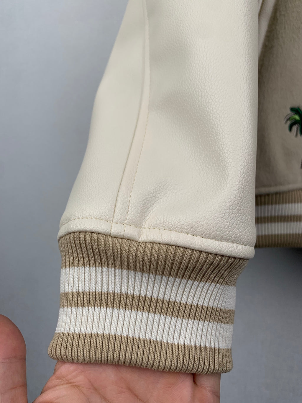 Beige Louis Vuitton sleeve hem with striped ribbed cuff and smooth trim