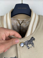 Beige Louis Vuitton jacket collar with striped rib trim and snap buttons visible