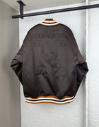 Back view of bomber jacket with striped ribbed collar and rhinestone-style lettering