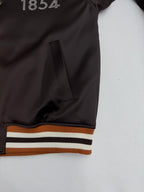 Side view of bomber jacket with pocket opening and striped ribbed waistband