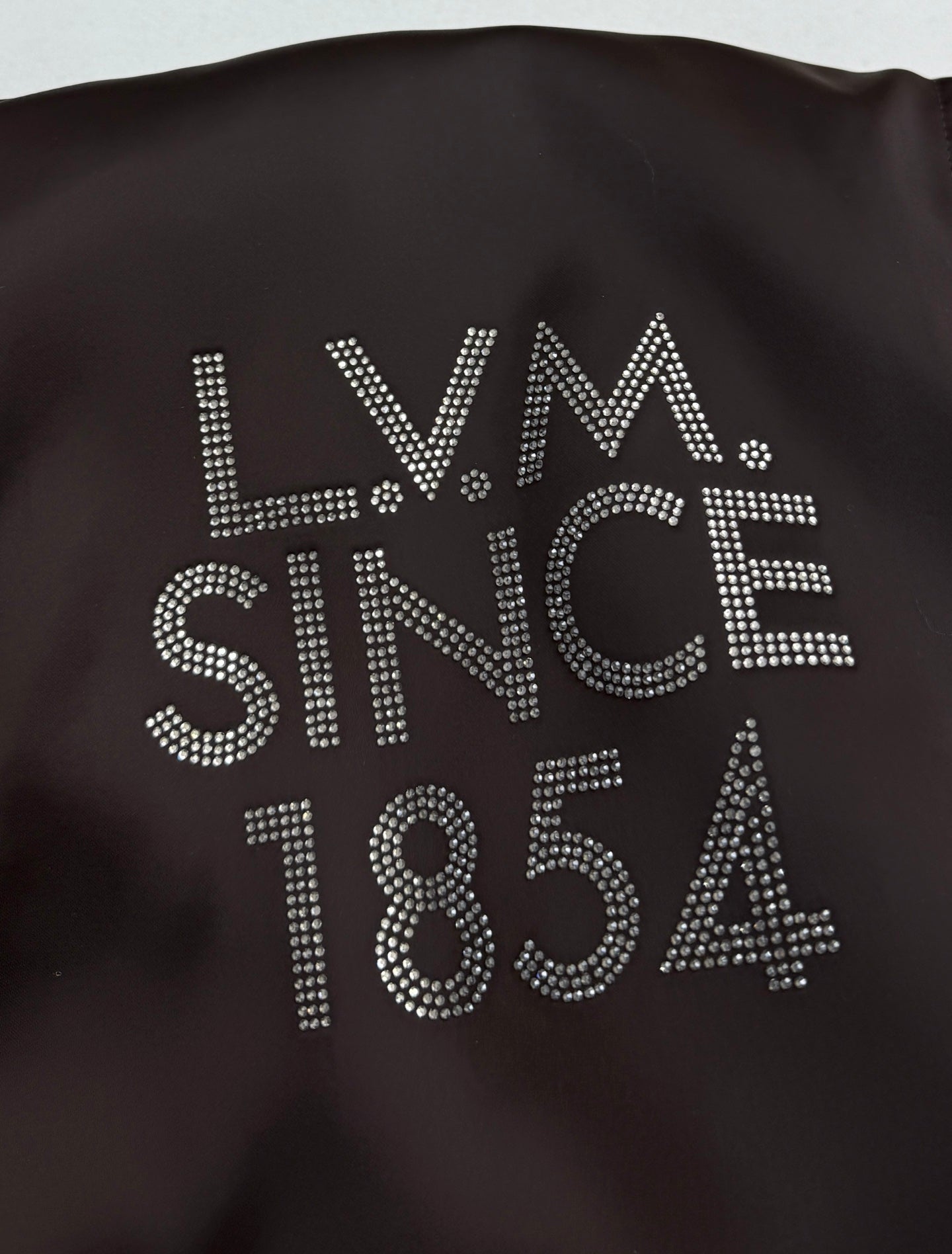 Bomber jacket back with rhinestone-style “LV” and “SINCE 1854” text