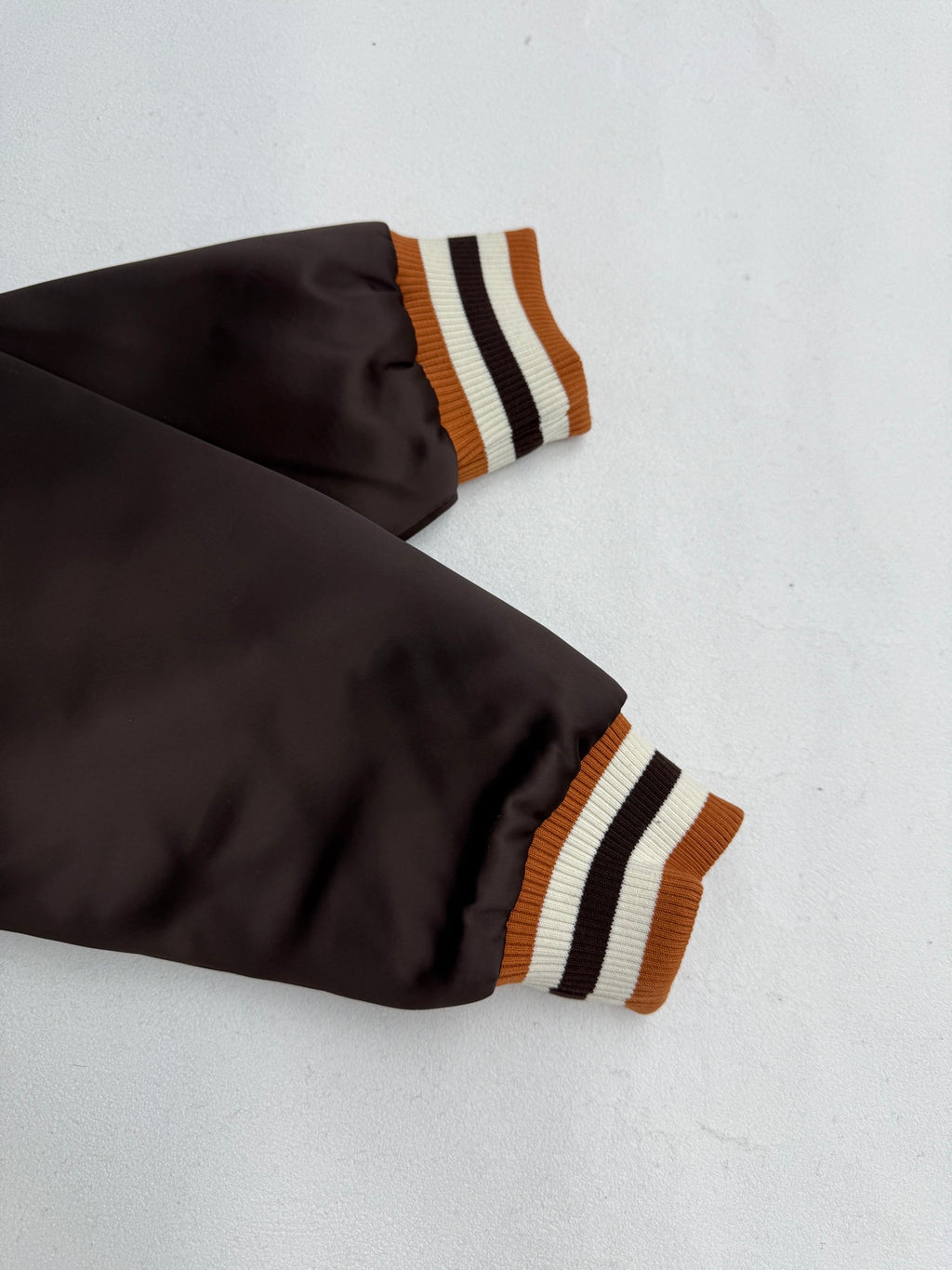 Louis Vuitton bomber jacket sleeves, dark satin with orange and striped ribbed cuffs