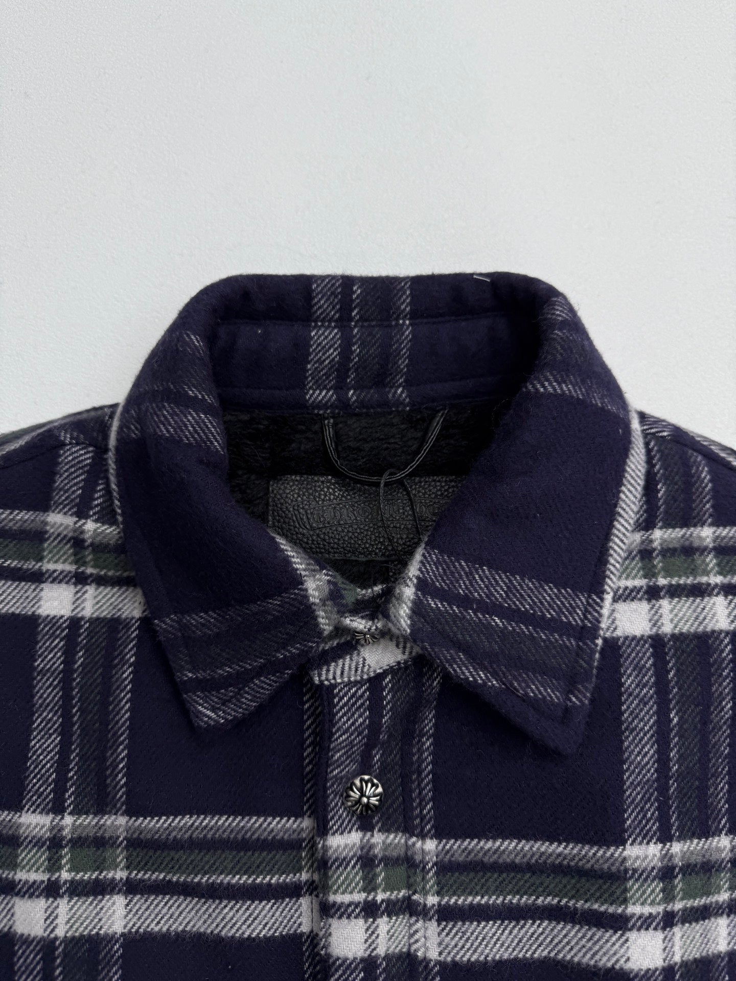 Plaid shirt-jacket collar detail with snap buttons and navy lining, navy and white checks