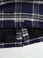 Long dark plaid jacket with front zipper and metal brand badge at collar