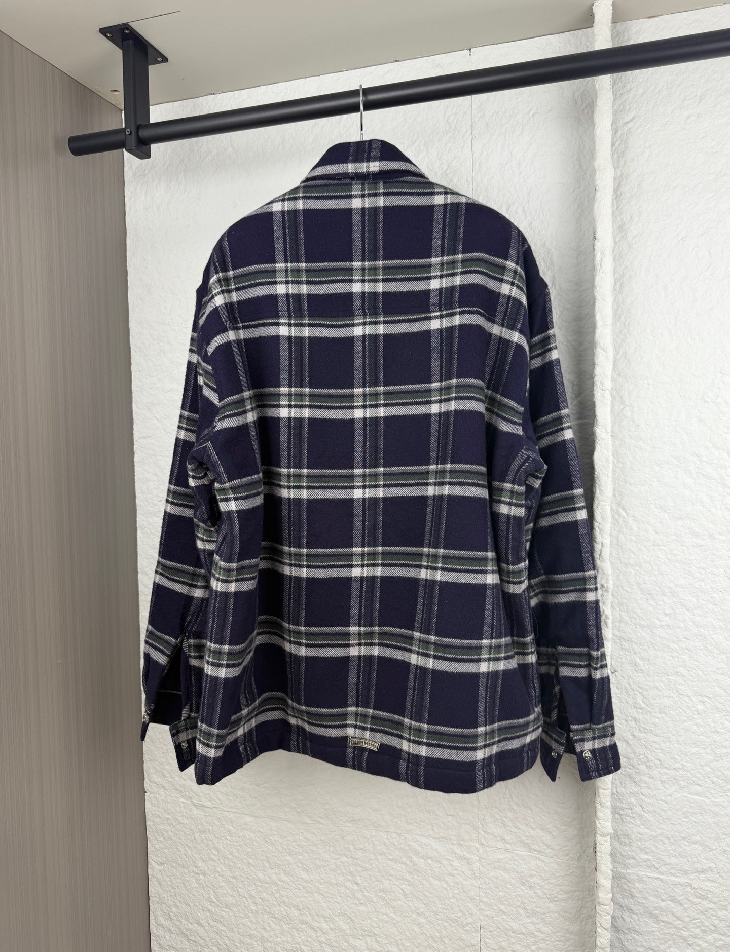 Plaid long-sleeve shirt-jacket back view with button cuffs, navy and white grid pattern