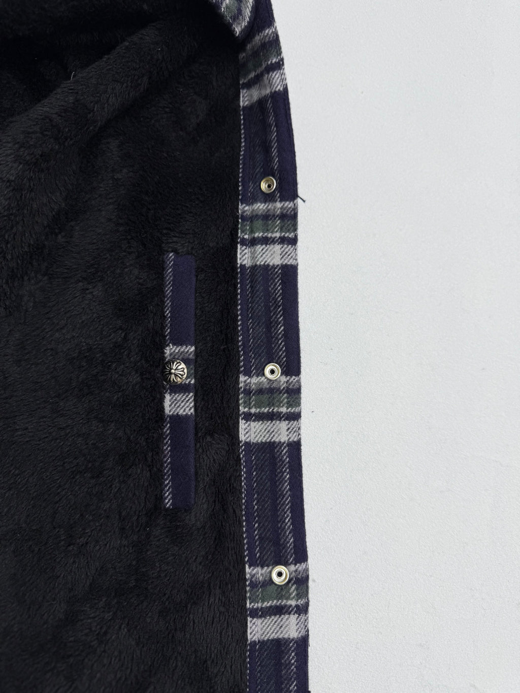 Plaid shirt-jacket side seam and pocket detail with metal snaps, navy and white checks