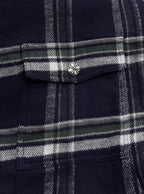 Plaid shirt-jacket chest pocket flap with metal button, navy and white grid pattern