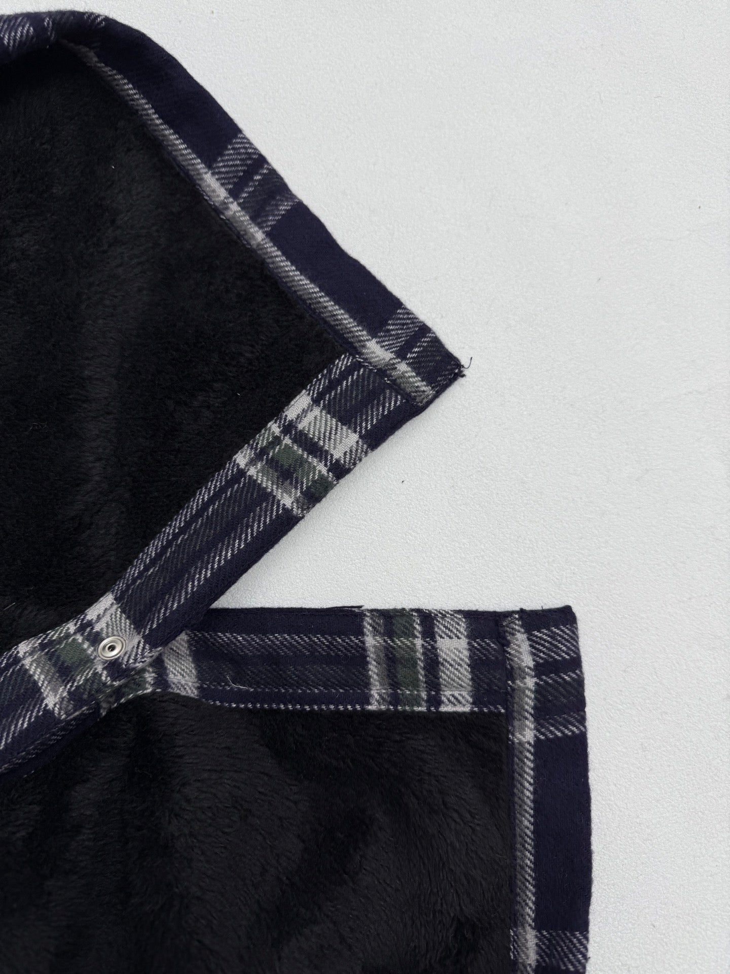 Plaid shirt-jacket shoulder and placket with snap buttons, navy and white checks