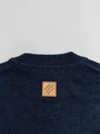 Navy knit sweater back neckline with brown brand patch label