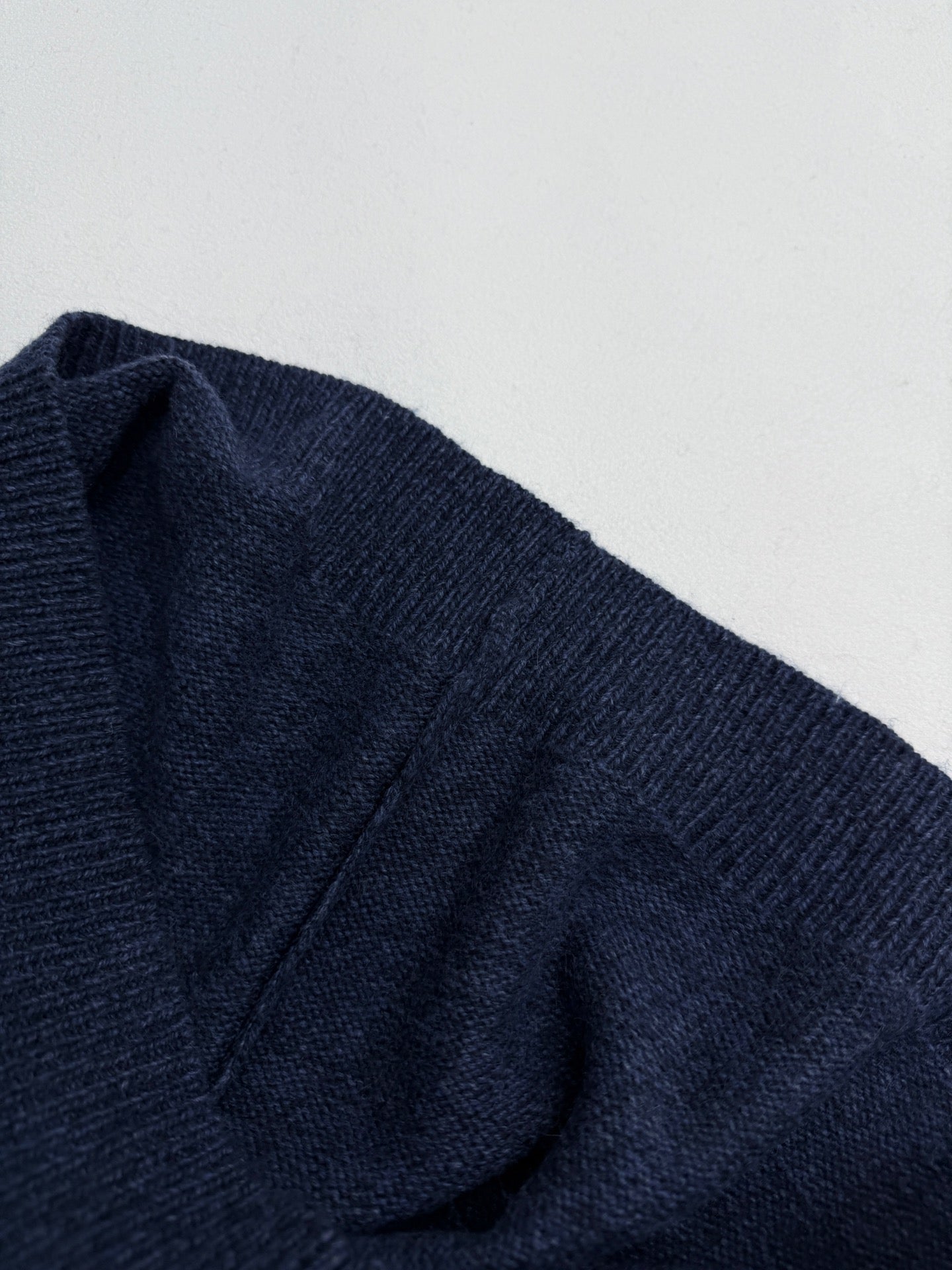 Navy knit sweater draped shoulder seam and knit texture detail