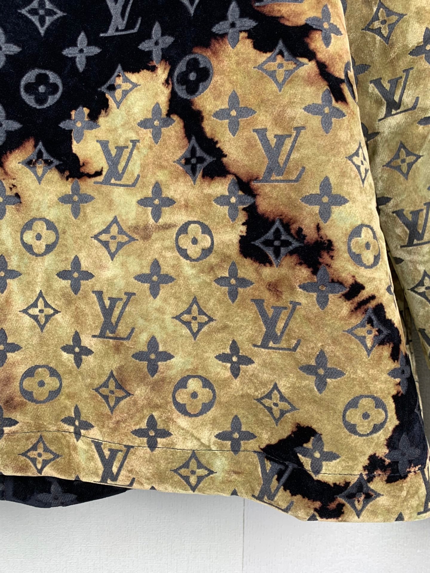 Quilted long jacket with navy and gold monogram pattern