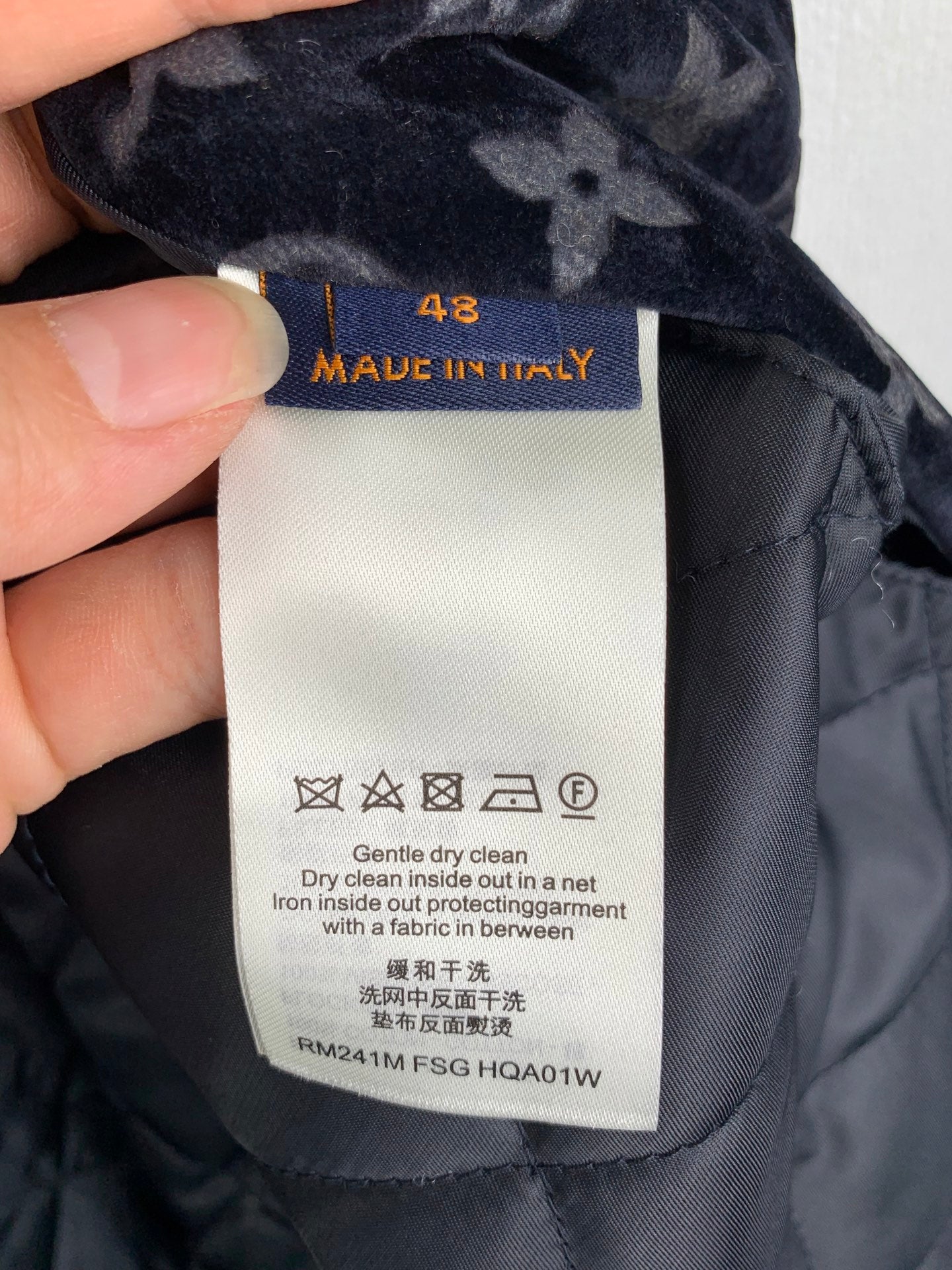 Fabric care label inside navy quilted jacket, Made in Italy