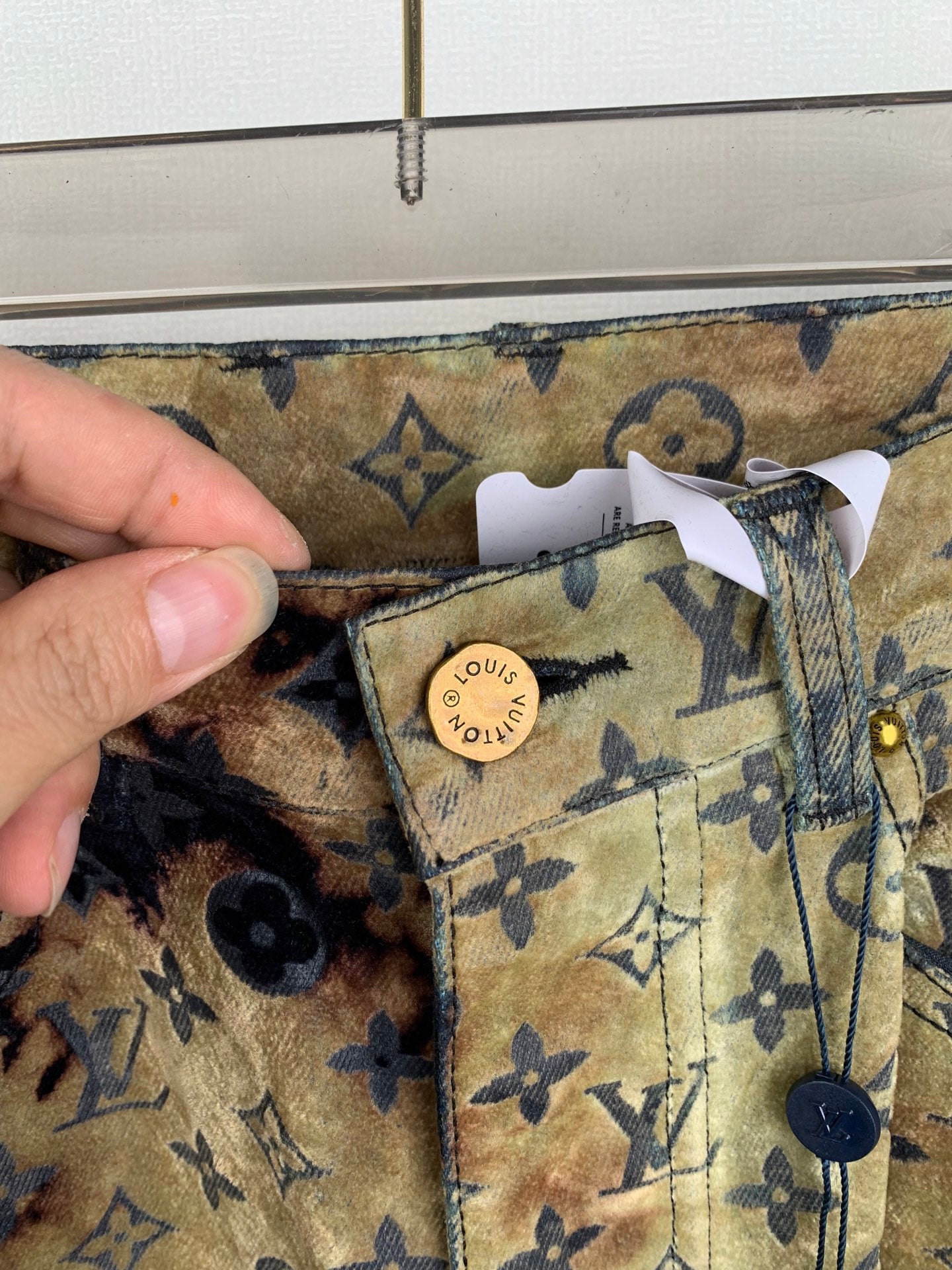 Louis Vuitton monogram long pants close-up: logo tag on pocket and stitching