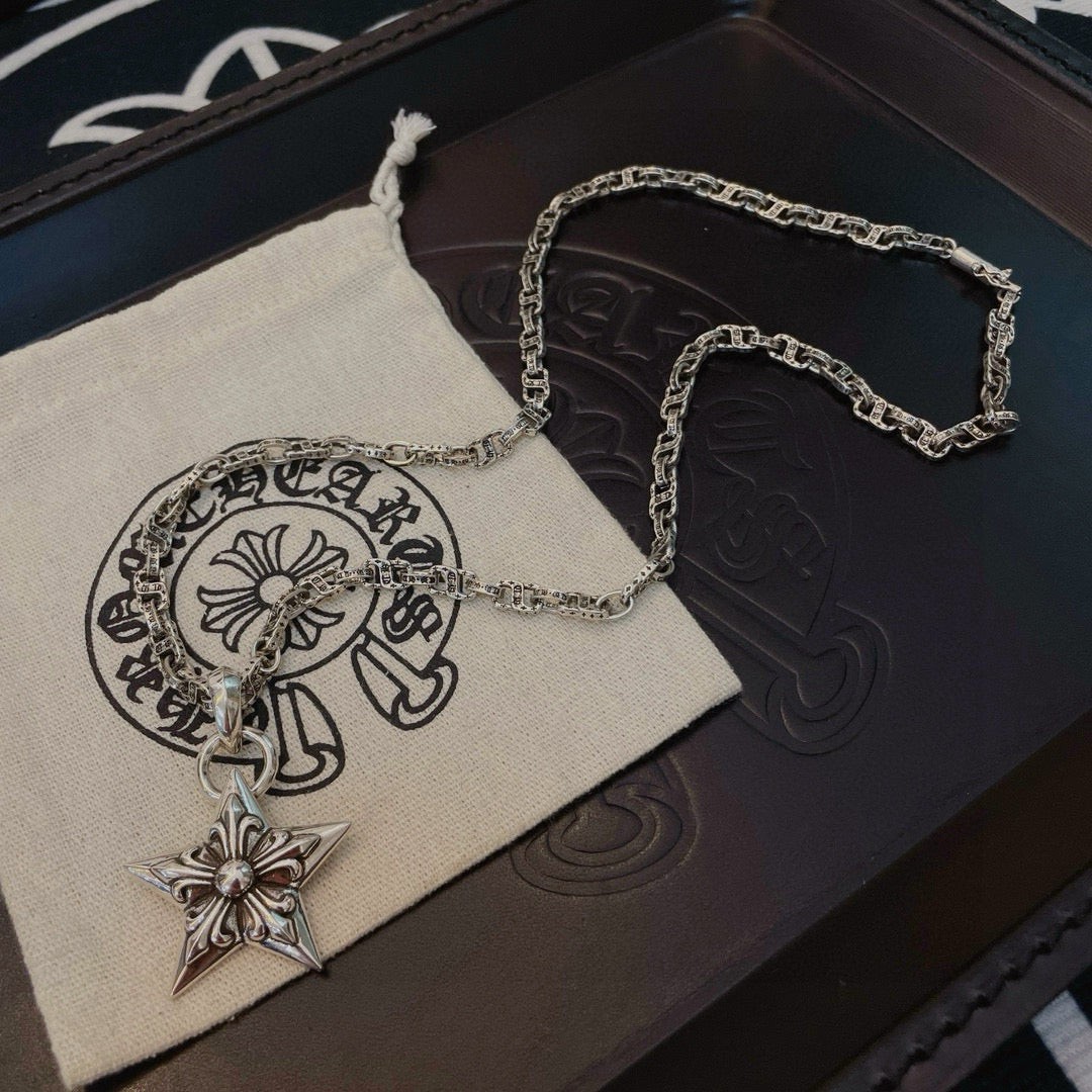 Silver chain necklace with star pendant on white pouch and dark box