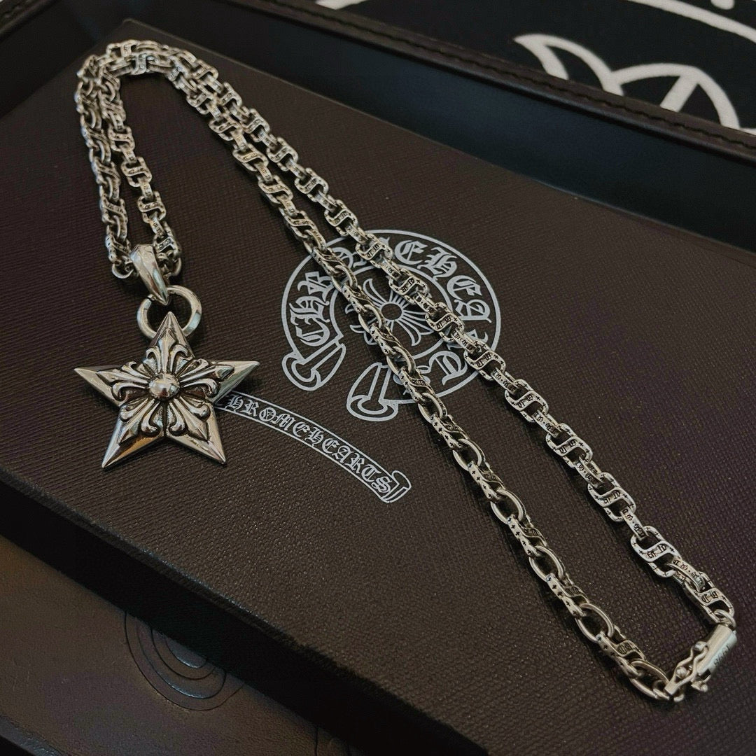 Silver chain necklaces with star pendant charms on dark box and pouch