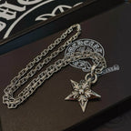 Silver chain necklace with star pendant charm on dark box