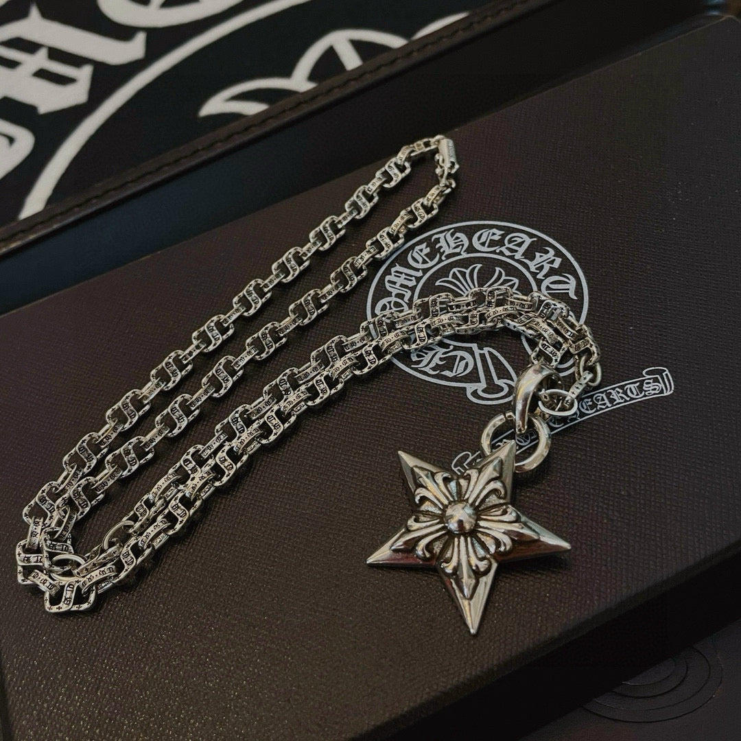 Silver chain necklace with star pendant charm on dark box