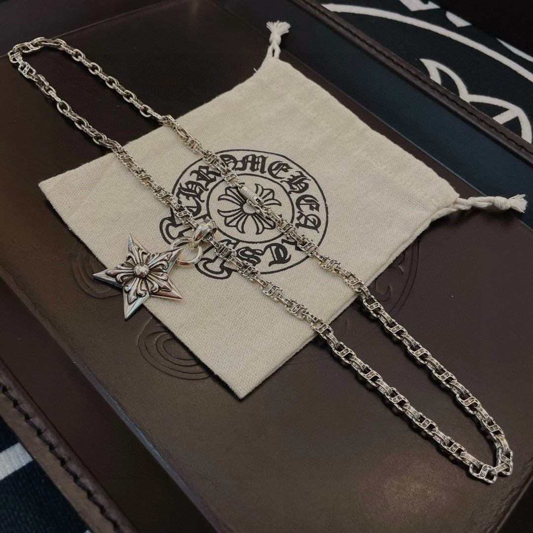 Silver chain necklace with star pendant charm on white pouch
