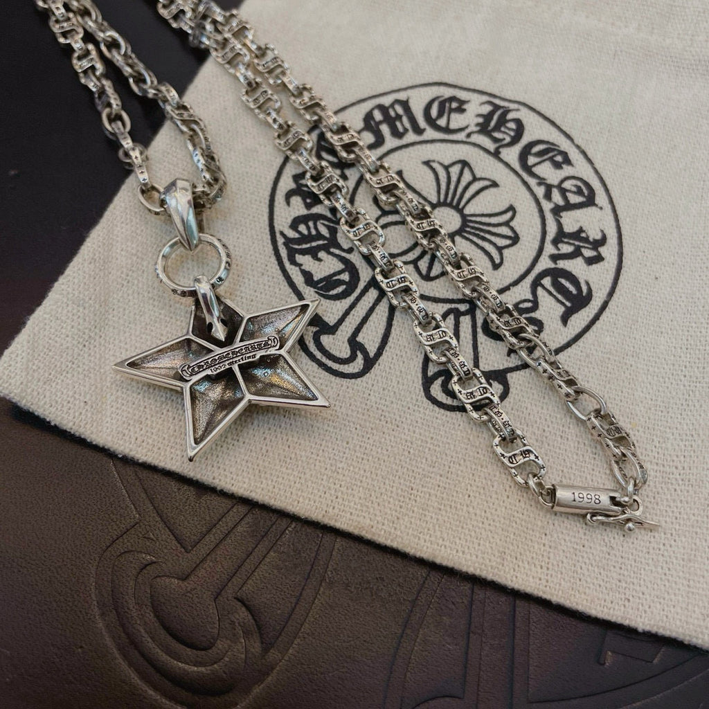Silver chain necklace with star pendant on white pouch, close-up