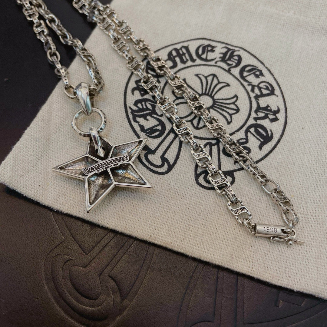 Silver chain necklace with star pendant on white pouch, close-up