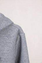 Light gray zip-up hoodie with stitched shoulder seam and relaxed sleeve shape.