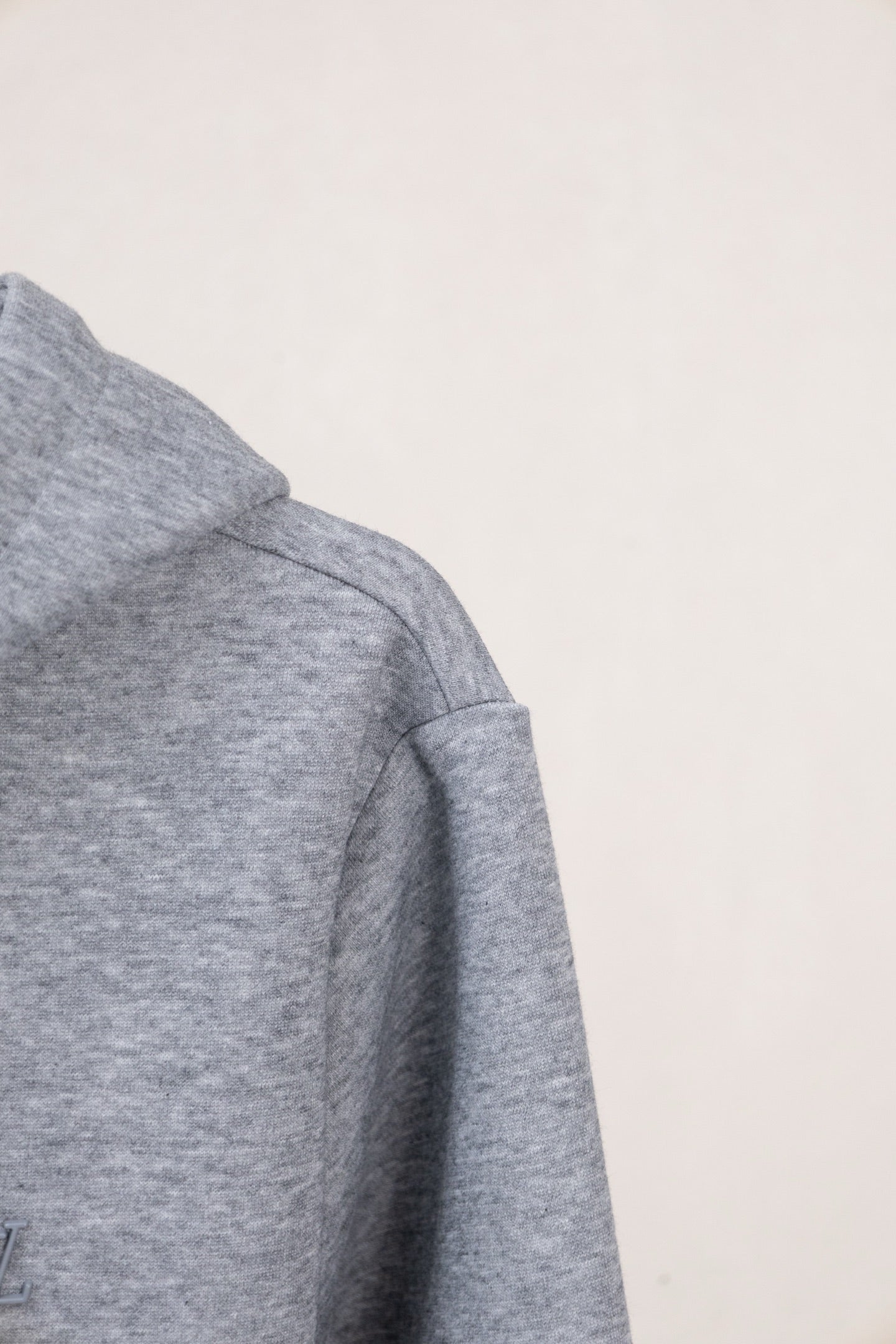 Light gray zip-up hoodie with stitched shoulder seam and relaxed sleeve shape.