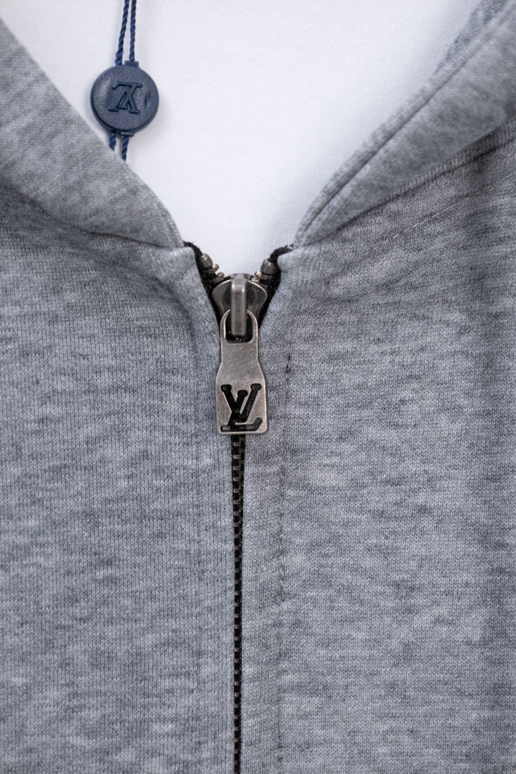 Light gray Louis Vuitton zip-up hoodie with metal zipper pull and closed collar.