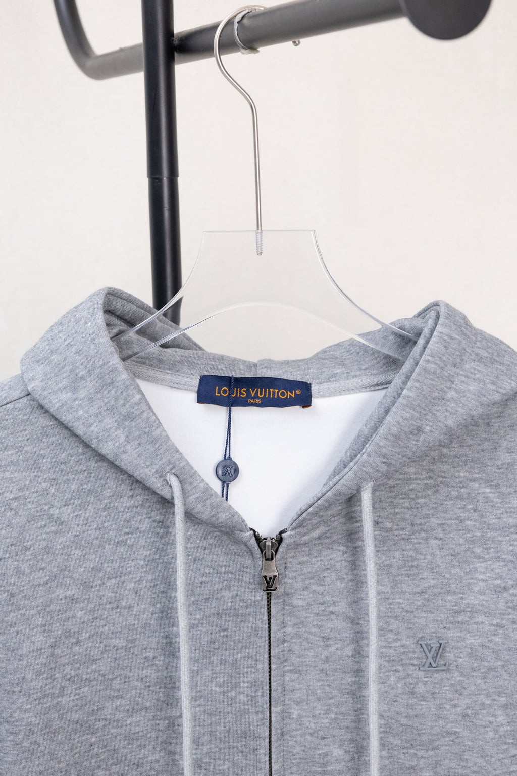 Light gray Louis Vuitton zip-up hoodie hood, drawstrings, and front zipper.