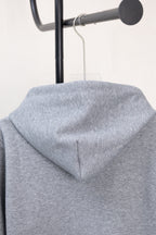 Light gray hoodie with draped hood and centered seam detail, no front zipper shown.
