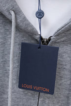 Light gray hoodie with Louis Vuitton hang tag on drawstring cord.