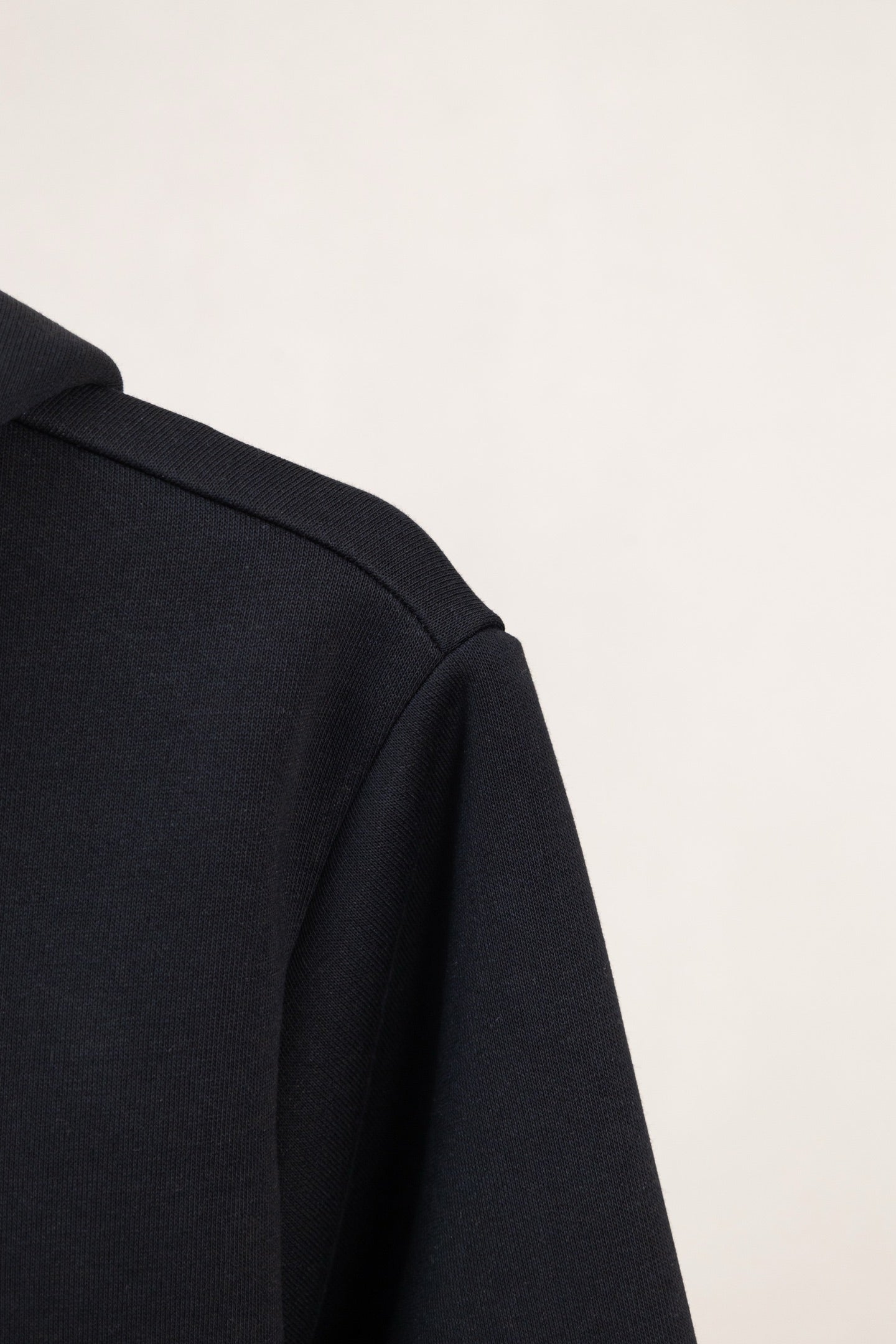 Dark navy hoodie shoulder and sleeve side seam with structured collar
