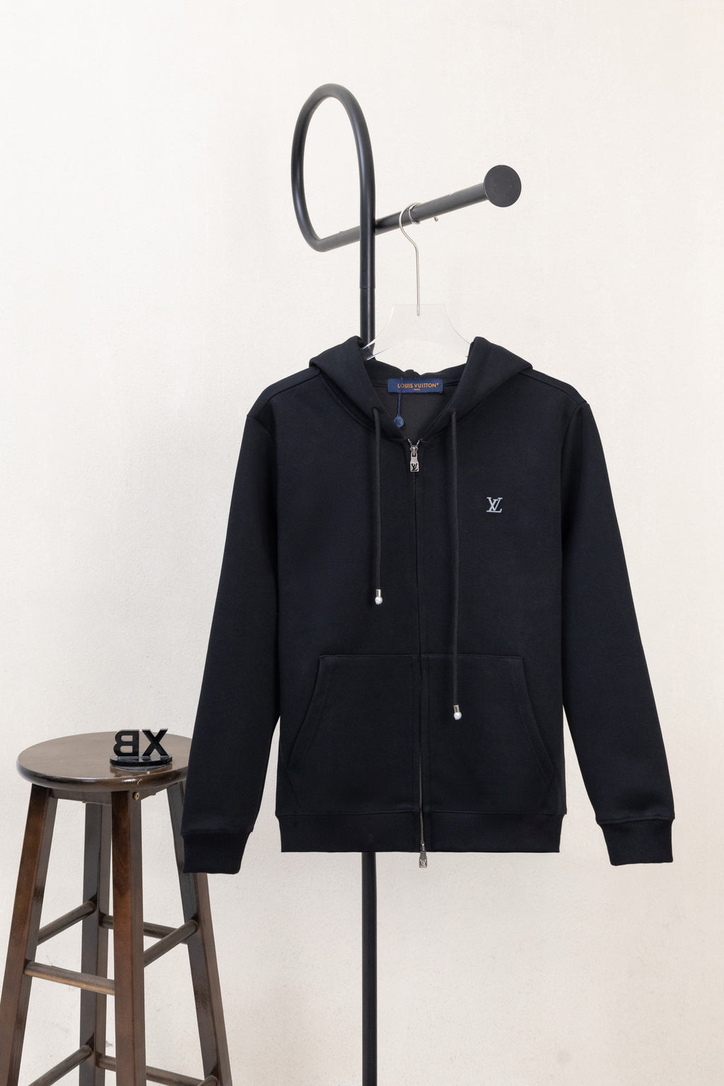 Dark navy zip-up hoodie with hood, drawstrings, and chest LV logo patch