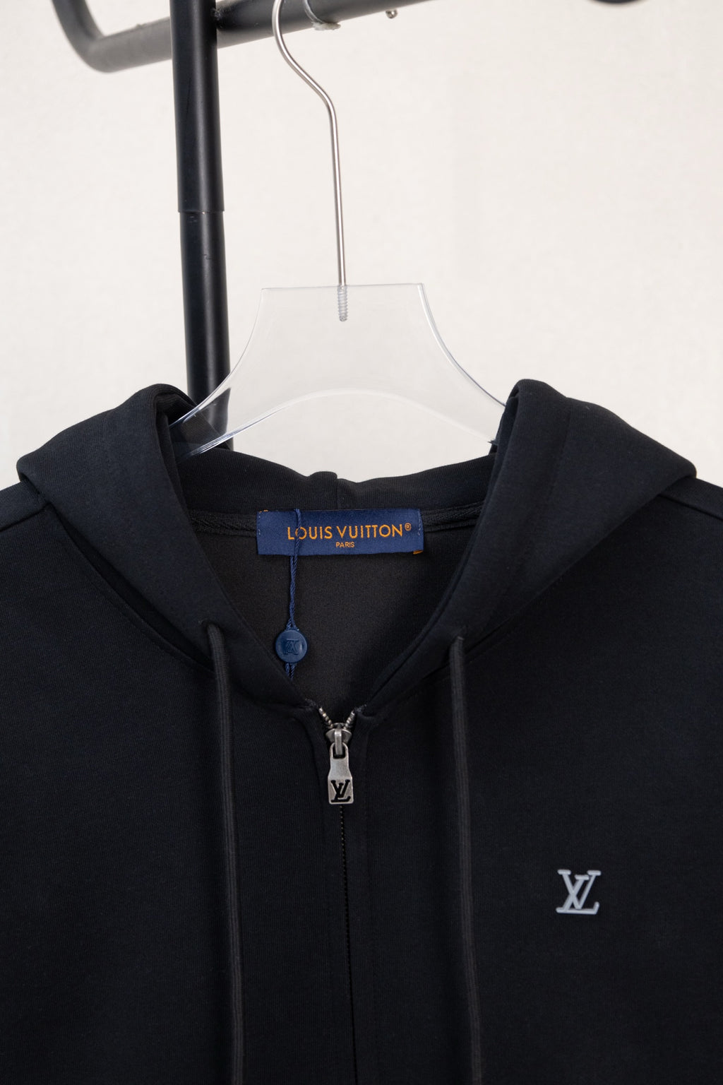 Dark navy zip-up hoodie close-up at hood and front neckline with metal zipper
