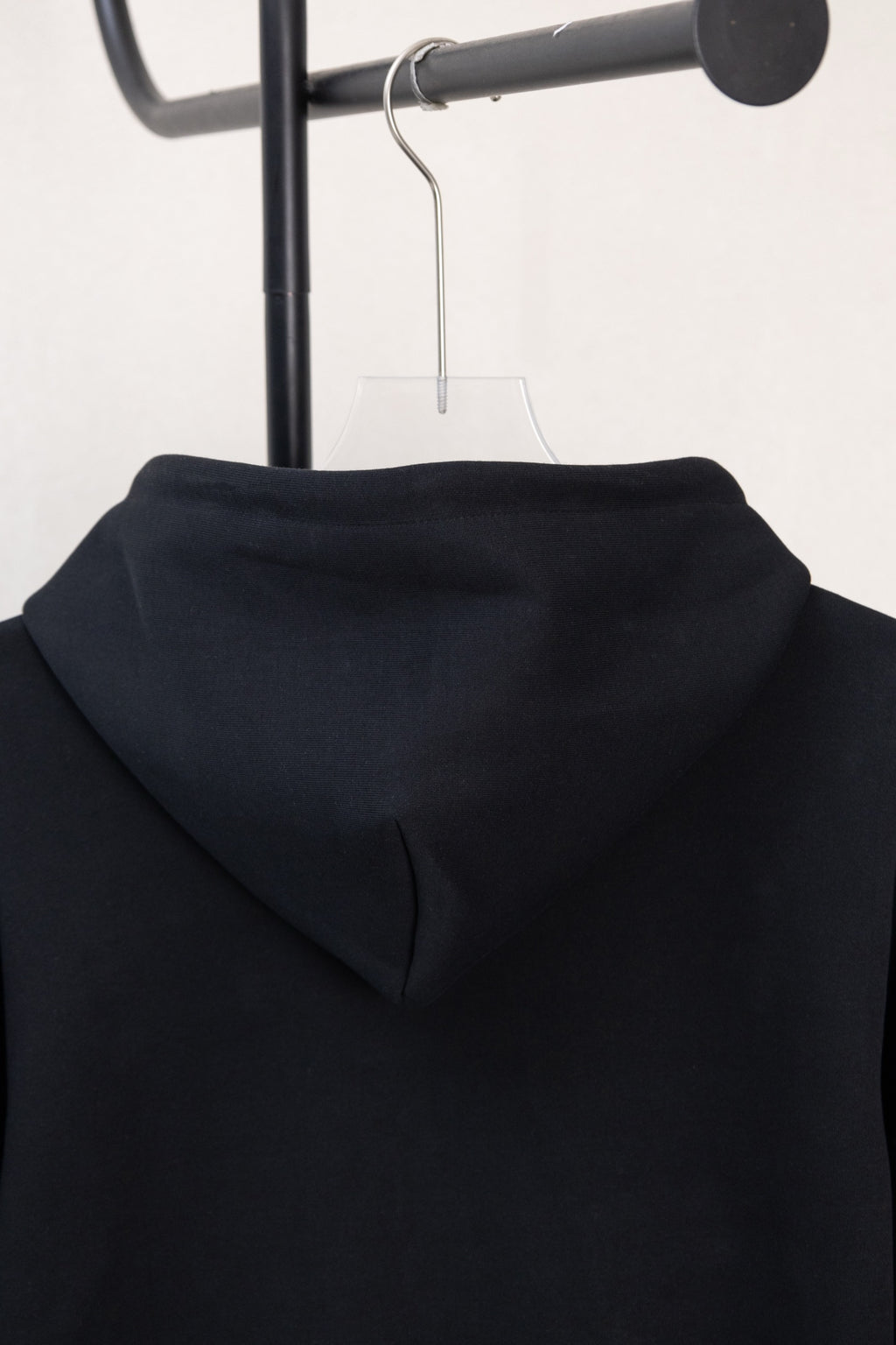 Dark navy hoodie back hood close-up with smooth fabric and folded seam