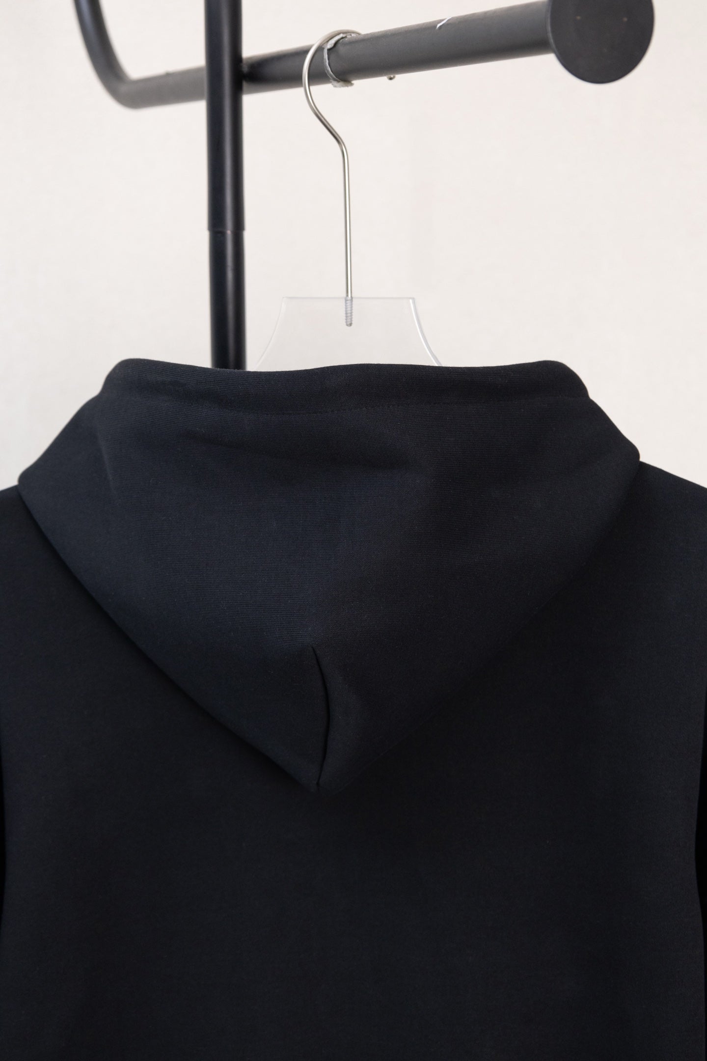 Dark navy hoodie back hood close-up with smooth fabric and folded seam