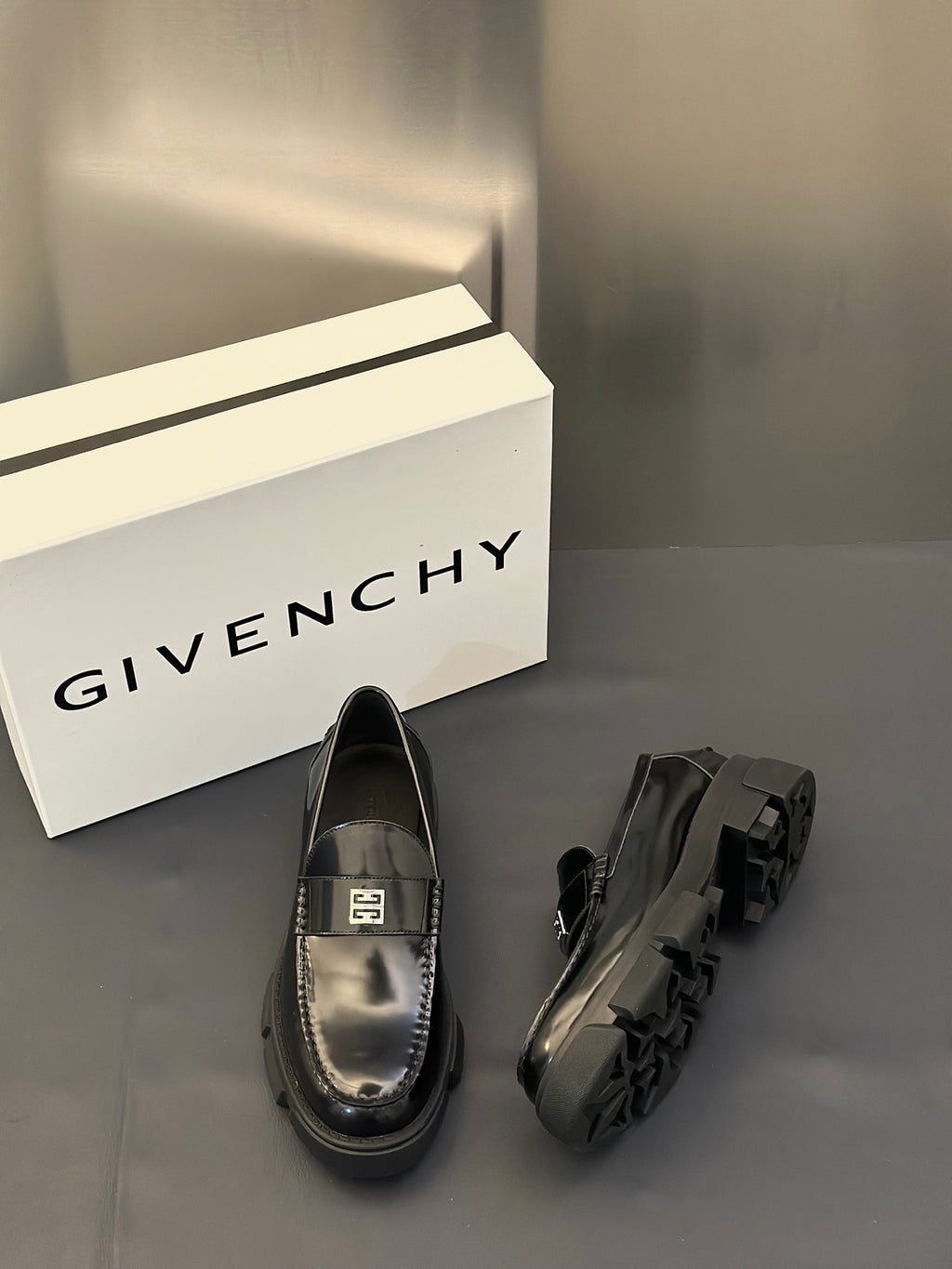 Black leather loafers with silver logo buckle and platform rubber heel