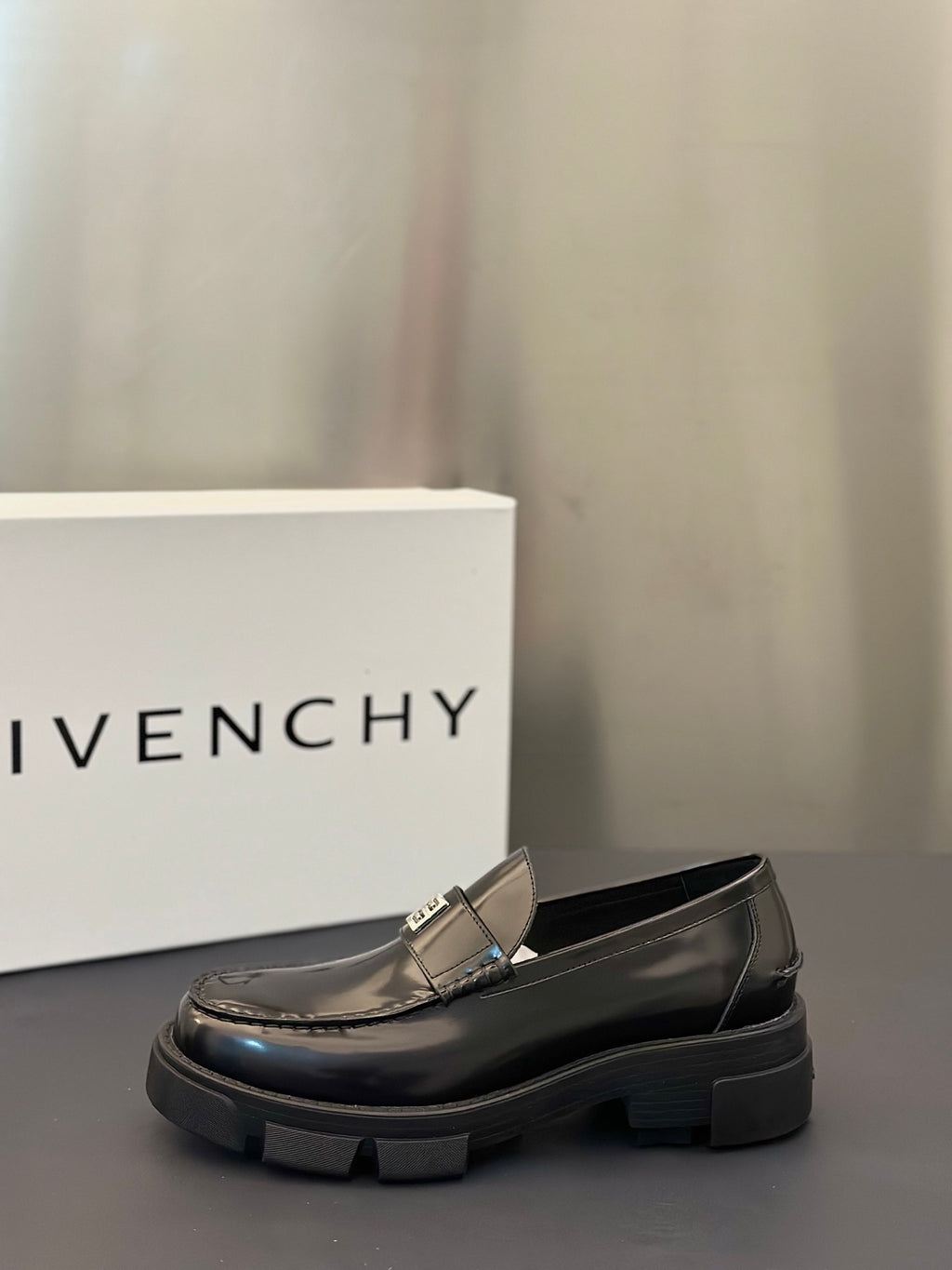 Black leather loafer with silver logo buckle and rounded toe