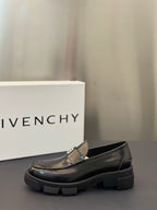 Black leather loafer with silver logo buckle and rounded toe